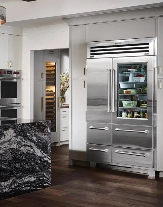 Sub-Zero refrigerator with a glass-front door and freezer drawers in a fitted kitchen
